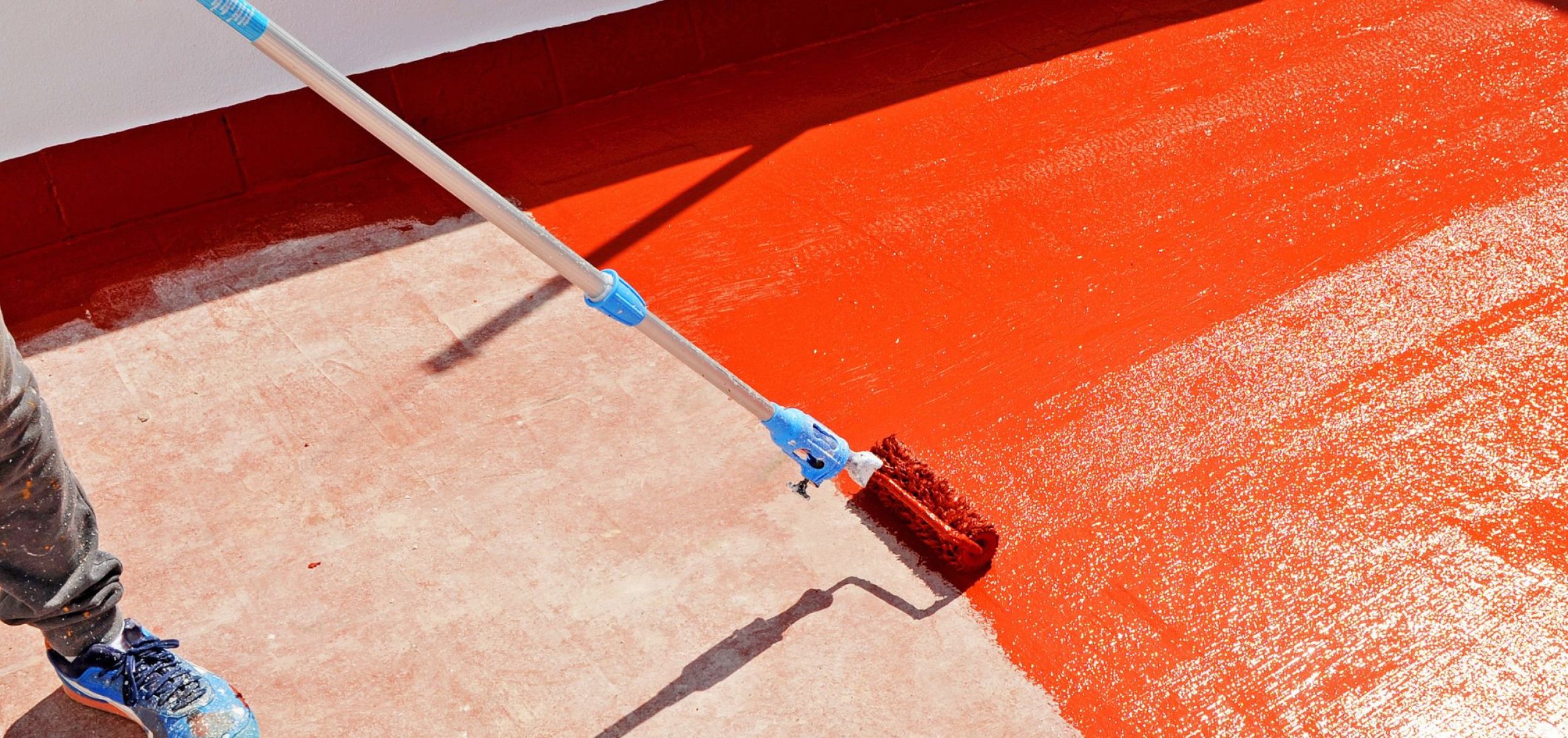 Aplicación de revestimiento impermeabilizante rojo en terraza exterior